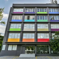 An example of adaptive reuse architecture. We converted a drab, old hotel building into a vibrant co-working space by giving the facade a modern grey finish and adding pops of color.