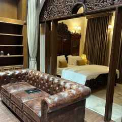 I love blending classic Indian aesthetics with luxurious comfort. This bedroom showcases our expertise in sourcing and integrating timeless pieces, like this intricately carved wooden headboard and archway, to create a space that feels like a royal heritage suite.