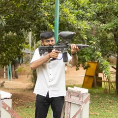 A team member gets into position for a paintball match. It's a thrilling game of strategy, teamwork, and quick reflexes.