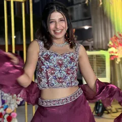 This maroon organza skirt set is fun and stylish. The handcrafted blouse is heavily embellished, while the skirt features playful ruffles at the bottom, creating a look that's both elegant and trendy.