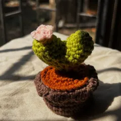 An adorable crochet cactus in the shape of a heart, complete with a little pink flower. The perfect zero-maintenance plant.