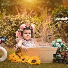 A tub full of sunshine and flowers. This outdoor baby photoshoot is a whimsical and adorable way to capture your little one enjoying nature.