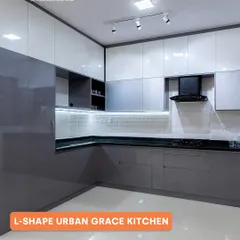 This L-shaped kitchen, named 'Urban Grace', features a sleek two-tone grey and white high-gloss finish. The layout opens up the room, making the space feel larger, while providing plenty of storage and a clean, modern aesthetic.