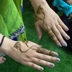 Another example of henna jewellery, this time with a peacock feather and leaf motif connected to the finger design.