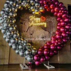 For a special anniversary celebration, I designed this large, freestanding heart-shaped balloon arch. The two-tone metallic balloons in silver and magenta, combined with a "Happy Anniversary" neon sign, create a perfect photo backdrop.