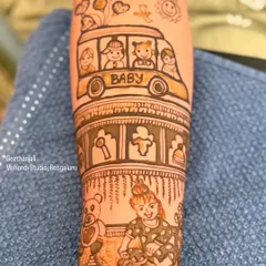 A close up of a custom baby shower mehendi. This design features a 'baby bus', a teddy bear, and a little girl playing, telling a sweet story of childhood.