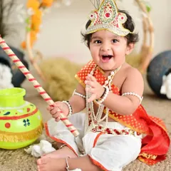 The joy on this little one's face says it all. Our themed shoots, like this popular Little Krishna setup, are all about playful imagination and creating truly unique memories.