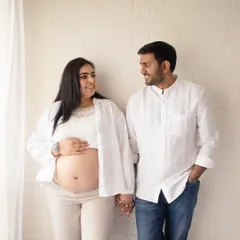 A simple, candid portrait of a couple holding hands. This shows the beauty of a relaxed, lifestyle maternity session, focusing on your natural connection in a comfortable setting.