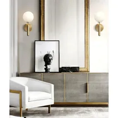 I love using wall lights to create symmetry and frame key features. Here, a pair of my modern globe sconces in a brushed brass finish flank a statement mirror, adding a layer of sophisticated, ambient light to the console area.
