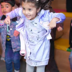 A young girl dances with joy, fully immersed in the party atmosphere.