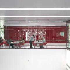 A mezzanine-level cafe at the KMC Headquarters overlooks the main atrium. These multi-level social spaces encourage visual connection and a sense of community among employees on different floors.