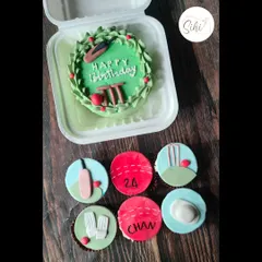 Bowled over. A cricket-themed bento cake and matching cupcakes, perfect for a sports lover's birthday. The set includes details like bats, balls, wickets, and pads.