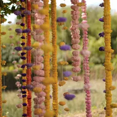 A close-up of the hanging floral garlands from our Indian bazaar-themed event. The combination of marigolds and fluffy cotton-like accents creates a playful and unique textural element, turning a simple garland into a piece of art.