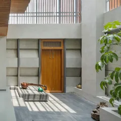 The central courtyard is the heart of the home, bathed in natural light from a slatted screen above. This space acts as a serene internal landscape, connecting different parts of the house and blurring the line between inside and out.