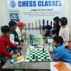 An instructor observes and guides students during a chess class. We provide proper study materials and a structured learning environment to help every child master the game.
