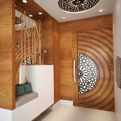 I designed this entryway with a stunning circular-patterned wooden door and a matching ceiling light fixture. The built-in seating nook provides a convenient spot to put on or take off shoes.