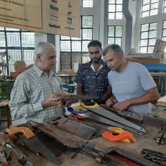 An instructor discusses the different types of hand saws with students. Understanding the right tool for the job is a key part of becoming a skilled woodworker.