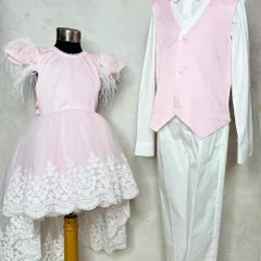 The cutest twinning look for a brother and sister. He wears a smart pink vest and white shirt, while she wears a beautiful pink dress with feather sleeves and a lace-trimmed high-low skirt.