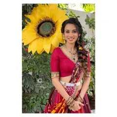 A full-length shot of Prathima's vibrant haldi look. The multi-colored lehenga-saree and the floral braid create a look that is playful, festive, and absolutely beautiful.