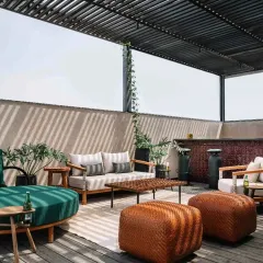 The rooftop entertainment lounge at Project 1374, designed for social gatherings. The open-sided pergola provides shade while maintaining a connection to the sky and surrounding views.