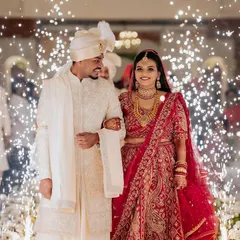 A grand entrance as husband and wife, walking through an aisle of cold pyrotechnics. This shot captures the drama and excitement of the reception, highlighting the couple's regal presence.