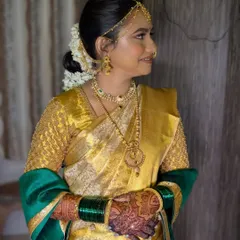 A side profile of Dhanashree's soft glam makeup, showing the clean hairstyle with a traditional gajra bun that perfectly complements her bridal look.