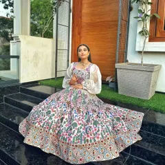 This raw silk lehenga is a canvas of multicolor floral embroidery, perfect for a bride who wants a touch of fairytale romance. The dramatic puff sleeves on the blouse add a modern, high-fashion element to the ensemble.
