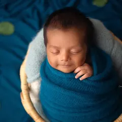 A sweet sleepy smile from this little boy, tucked into a basket. The contrast of the blue wrap against the natural basket fibers is just beautiful.