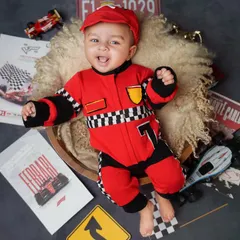 Ready, set, go! This little F1 driver is all smiles in his racing suit, surrounded by Ferrari and Monte Carlo props for a high-speed, super fun baby photoshoot.