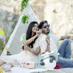 A fun picnic-themed pre-wedding shot, with a couple blowing bubbles and relaxing in a teepee tent setup.