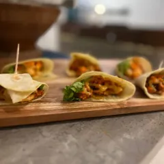 These mini tortilla wraps are filled with seasoned chicken and fresh greens, making for a perfect pass-around appetizer. They are easy to handle and packed with flavor, ideal for mingling.