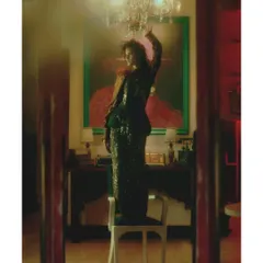 A scene of daring expression from "Love in Future Past." The composition, with the model standing on a chair under a chandelier, is meant to feel spontaneous and defiant, breaking from the quiet nostalgia of earlier chapters.
