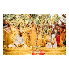The vibrant energy of a Haldi ceremony. I capture the joy and chaos as family and friends shower the couple with flowers and blessings, a key part of many Indian wedding traditions.