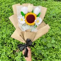I love how this rustic bouquet turned out. It combines a bright crochet sunflower with white tulips and daisies, all wrapped in simple brown craft paper with a black ribbon. It has such a natural and charming feel.