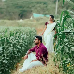 A serene moment in a lush cornfield, with the couple dressed in traditional Kerala attire. The simplicity of the white mundu and saree against the green landscape is timeless.