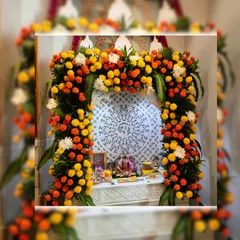 A classic marigold arch for a home mandir. We used vibrant orange and yellow marigolds with touches of white flowers to frame this beautiful white marble prayer space, highlighting the 'Om' carving.