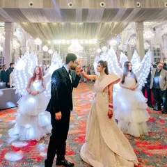 The couple's grand reception entrance, flanked by performers dressed as angels with illuminated wings.