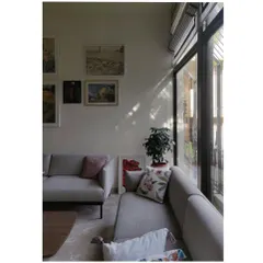 A wider view showing how the window frames create a grid of light on the wall and floor, adding a dynamic geometric element to the space.