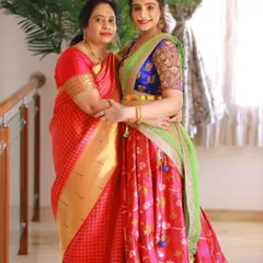 This mother-daughter duo showcases how coordinated outfits can celebrate individual style. I designed a vibrant half saree for the daughter with intricate aari work on the blouse, which beautifully complements her mother's classic silk saree, creating a stunning and connected look.