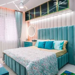 A full view of the teal-themed bedroom, showing the upholstered bed, matching side table, and overhead storage. The design is cohesive, calming, and perfect for a child's room.