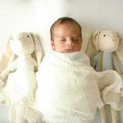 A close-up of the baby with two adorable bunny friends. The all-white theme is simple, pure, and timeless.