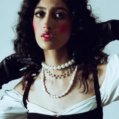 A close-up of the dramatic makeup, showing the bright red blush applied high on the cheeks and the glossy red lip.