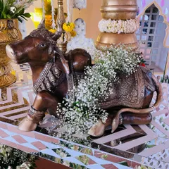 A detailed shot of a brass Nandi statue, adorned with delicate baby's breath. It's these small, thoughtful touches that enrich the decor.