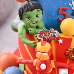Here's the Hulk smashing through the side of the cake, with a tiny Iron Man below. It took four days to create all the detailed, handmade elements for this superhero-themed cake.