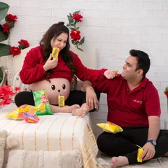Another angle from our playful "Frooti" session. The candid interaction between the parents as they share a snack creates a genuine and heartwarming memory.