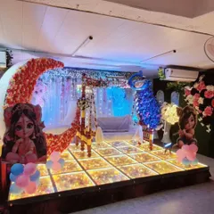 This is another one of our popular naming ceremony themes. The stage features a traditional cradle, a large decorative moon, and cute character cutouts, all under beautiful lighting.
