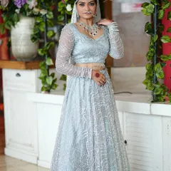 A full-length view of the modern reception lehenga. The intricate beadwork of the outfit is complemented by sleek hair and diamond jewelry for a truly show-stopping look.