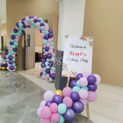 A welcome area for Aanvi's birthday party, featuring a personalized sign on an easel and a lovely pastel balloon arrangement.