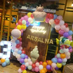 A sweet and colorful Candyland theme for Arsalna's 3rd birthday. This setup features a vibrant circular balloon arch, a custom "Happy Birthday" neon sign, and fun foil balloons like ice cream cones and candy. The light-up marquee number '3' makes the birthday girl feel extra special.