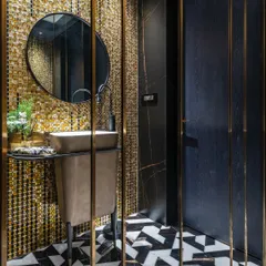 For this powder room, we used shimmering gold mosaic tiles to create a glamorous feature wall. A freestanding basin and black and white geometric floor tiles complete this opulent and high-impact design.